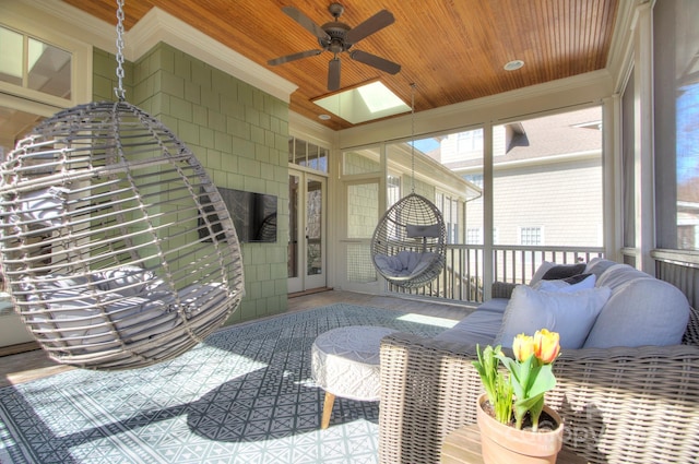 sunroom featuring a ceiling fan and wood ceiling