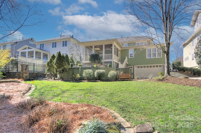 view of front of home featuring an attached garage, a front yard, and a sunroom