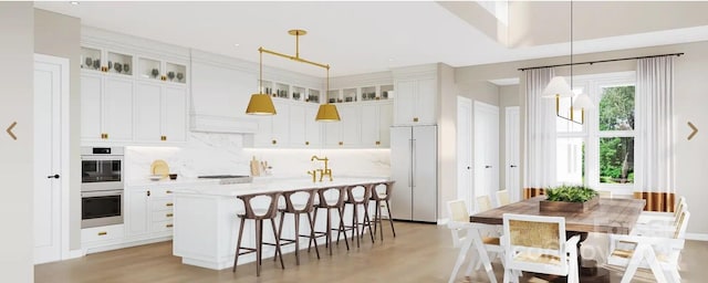 kitchen with glass insert cabinets, hanging light fixtures, and built in fridge