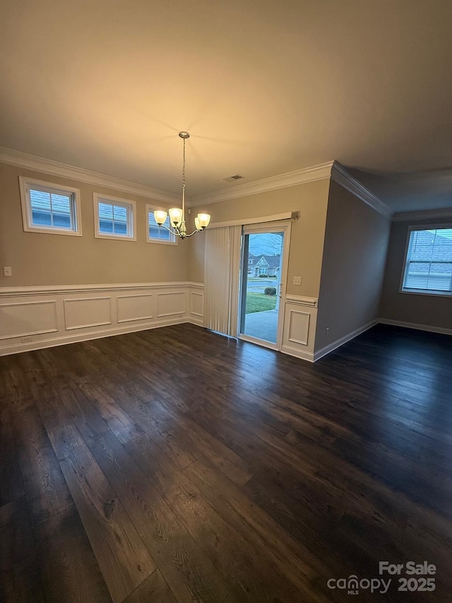 unfurnished dining area with an inviting chandelier, visible vents, dark wood-style floors, and ornamental molding