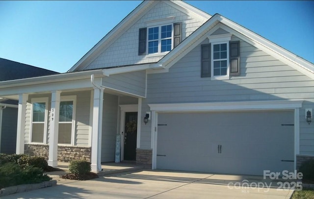 craftsman inspired home featuring covered porch, stone siding, and driveway