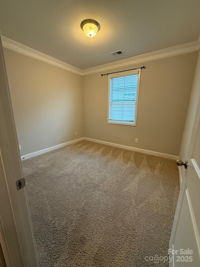 carpeted spare room featuring visible vents, crown molding, and baseboards