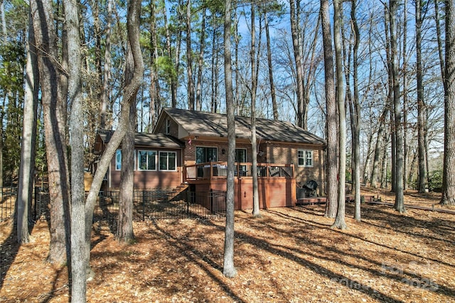 view of front facade with stairway, a deck, and brick siding