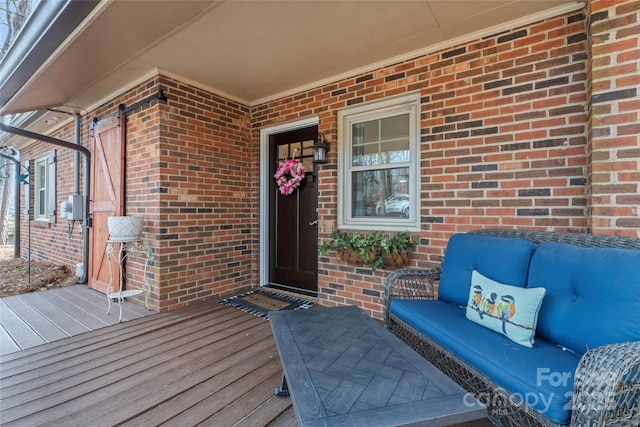 view of exterior entry featuring brick siding and an outdoor hangout area