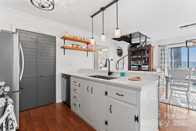 kitchen featuring a peninsula, dark wood-type flooring, a sink, white cabinetry, and appliances with stainless steel finishes