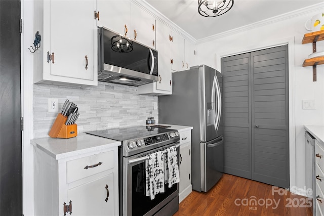 kitchen featuring dark wood finished floors, crown molding, light countertops, decorative backsplash, and appliances with stainless steel finishes