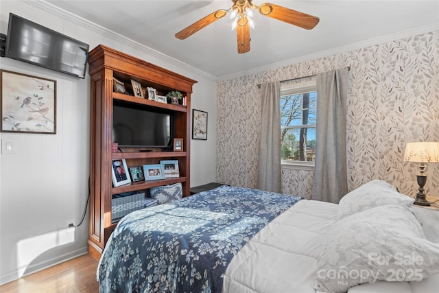 bedroom featuring wallpapered walls, a ceiling fan, ornamental molding, and wood finished floors