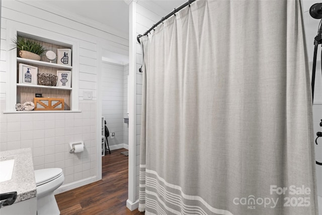 full bathroom with wood walls, vanity, toilet, and wood finished floors