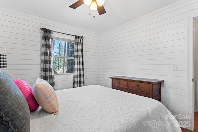 bedroom with wood walls and a ceiling fan