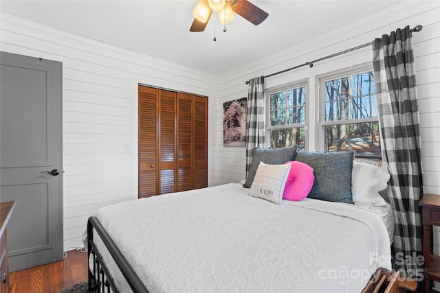 bedroom featuring a closet, wood finished floors, and a ceiling fan