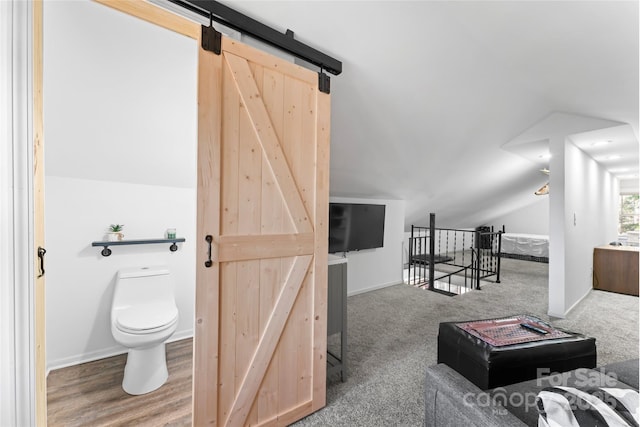 interior space with lofted ceiling, baseboards, and toilet