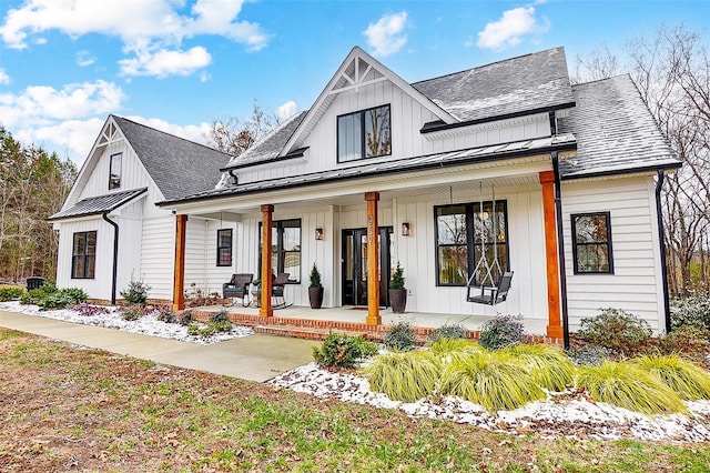 modern inspired farmhouse with a porch, a standing seam roof, and a shingled roof