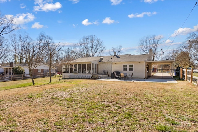 back of house featuring a sunroom, a fenced backyard, a chimney, a yard, and a patio area