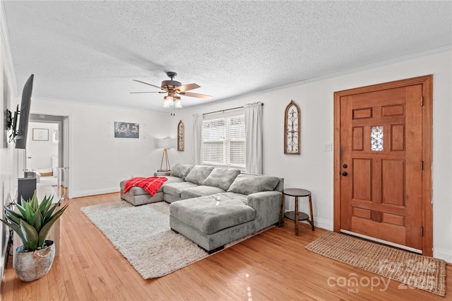 living area with a textured ceiling, ceiling fan, wood finished floors, and baseboards