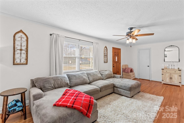 living area featuring a textured ceiling, ceiling fan, and wood finished floors