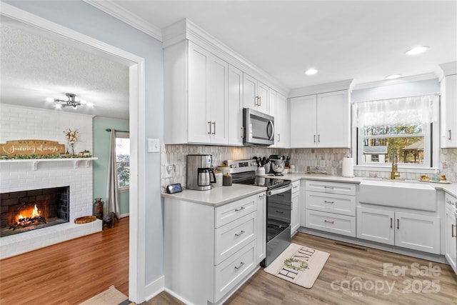 kitchen with appliances with stainless steel finishes, light countertops, and white cabinetry