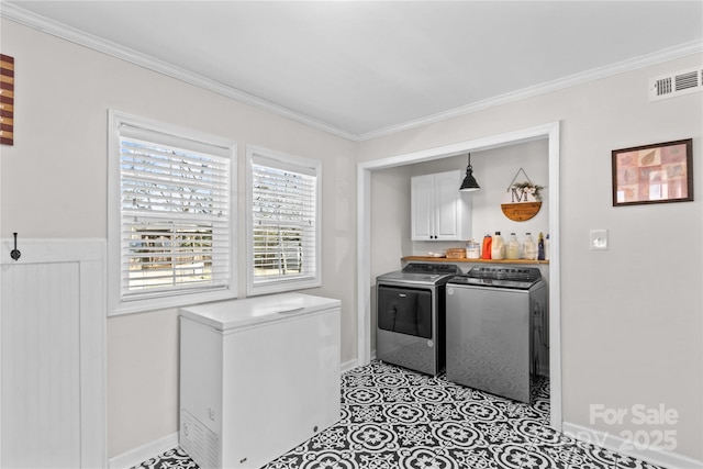 washroom featuring ornamental molding, visible vents, cabinet space, and separate washer and dryer