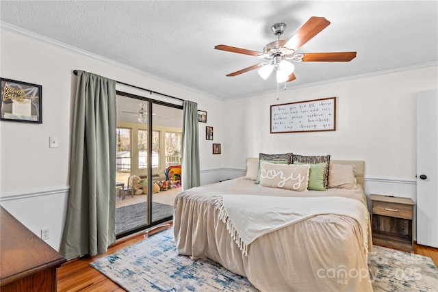 bedroom with a textured ceiling, a ceiling fan, access to outside, light wood finished floors, and crown molding