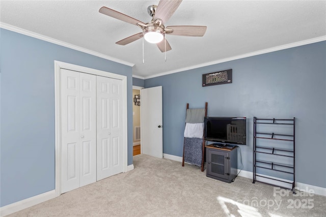 bedroom featuring light carpet, crown molding, baseboards, and a closet