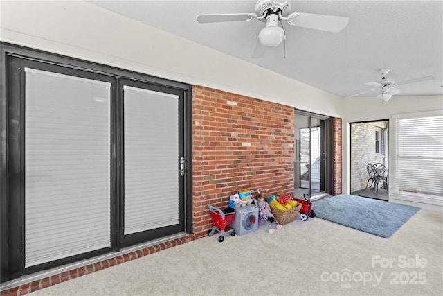 interior space with a textured ceiling, dark carpet, and a ceiling fan