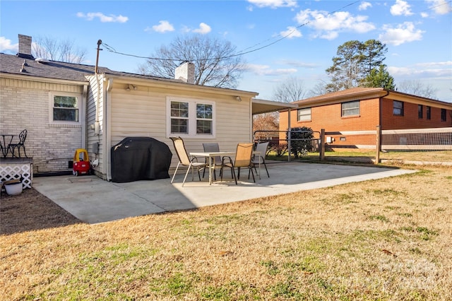 rear view of house featuring a yard, a patio, a chimney, and fence