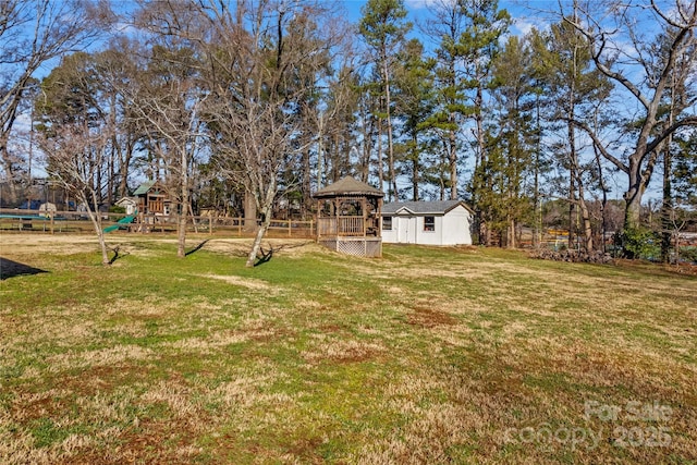 view of yard with a gazebo, a playground, and fence