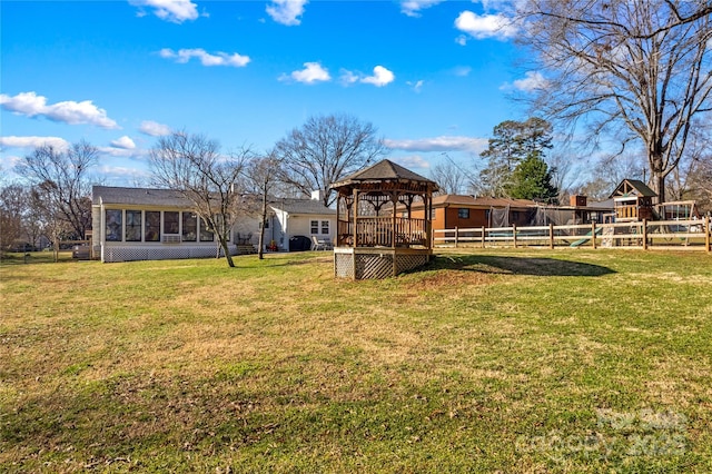 view of yard featuring a sunroom, fence, and a gazebo