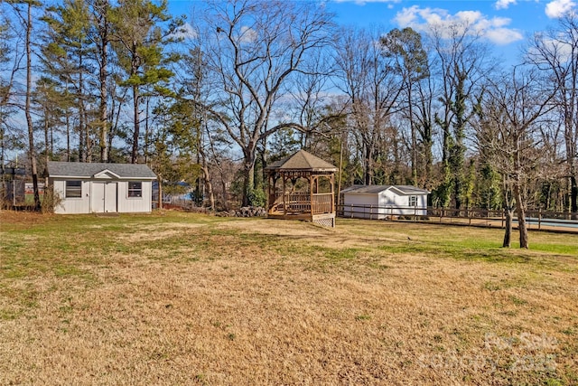 view of yard with an outdoor structure, a gazebo, and fence