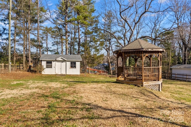 view of yard with an outdoor structure, a wooden deck, a gazebo, and fence