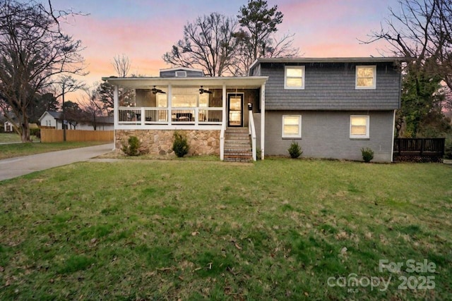 tri-level home with concrete driveway, a front yard, and a ceiling fan