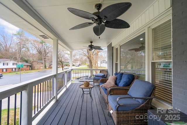 wooden terrace with covered porch, ceiling fan, and a residential view