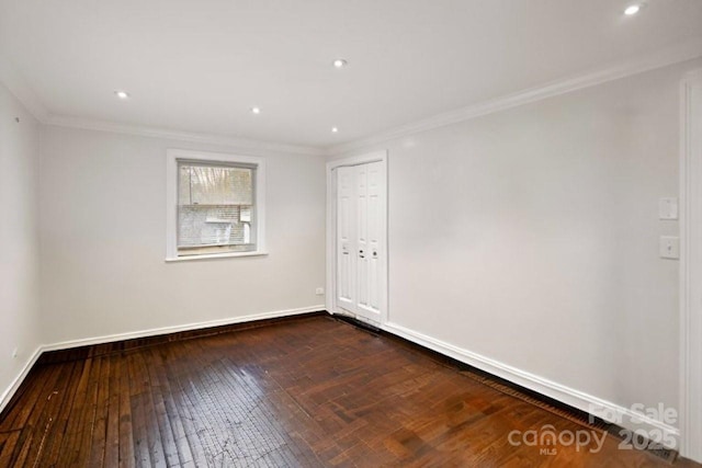 unfurnished room with baseboards, ornamental molding, and dark wood finished floors