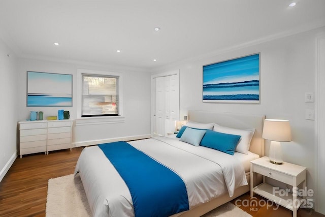 bedroom with recessed lighting, a closet, crown molding, and wood finished floors