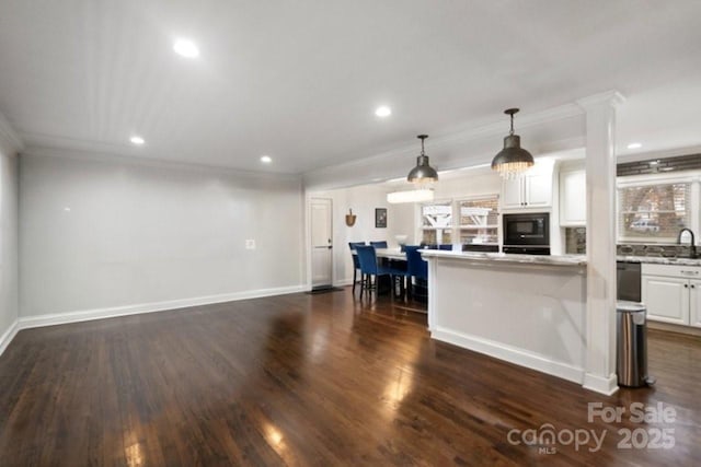 kitchen featuring black microwave, white cabinetry, crown molding, and dark wood-style flooring