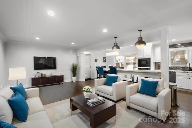 living room with baseboards, ornamental molding, wood finished floors, and recessed lighting