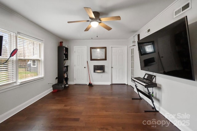 interior space with baseboards, visible vents, wood finished floors, and ornamental molding