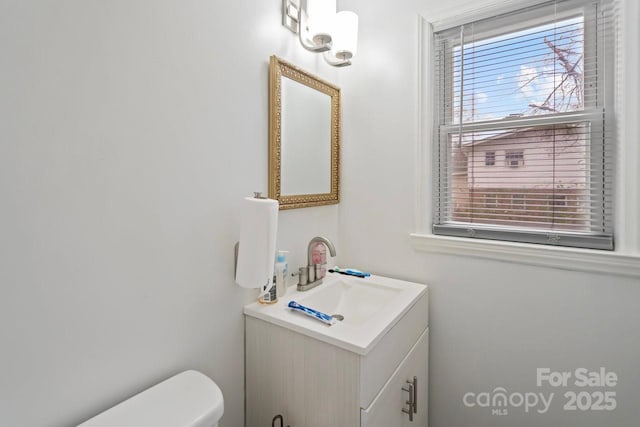 bathroom featuring plenty of natural light, vanity, and toilet