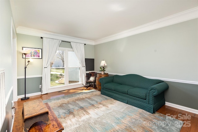 living area featuring crown molding, baseboards, and wood finished floors