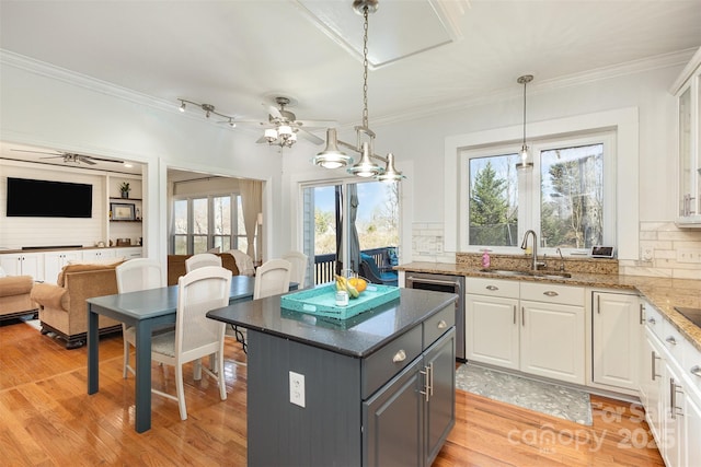 kitchen featuring stainless steel dishwasher, a sink, and white cabinetry