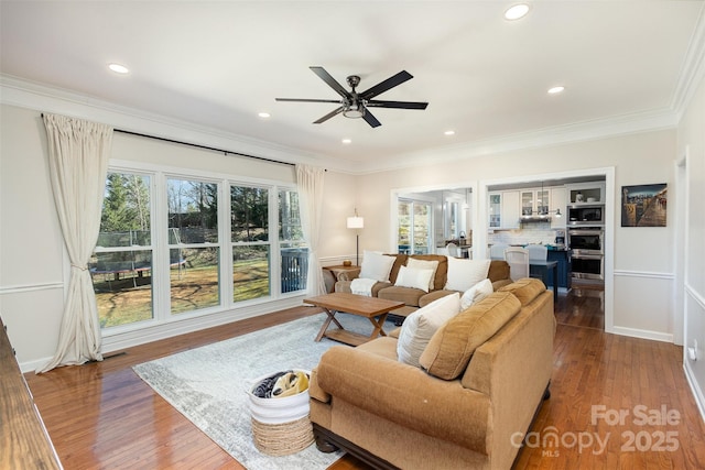 living room featuring ceiling fan, recessed lighting, crown molding, and wood finished floors