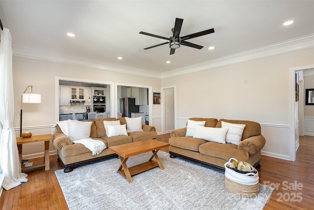 living room featuring a ceiling fan, ornamental molding, wood finished floors, and recessed lighting