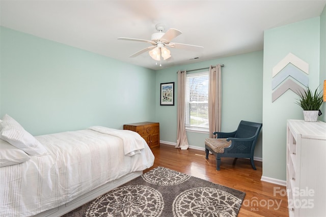 bedroom featuring ceiling fan, baseboards, and wood finished floors