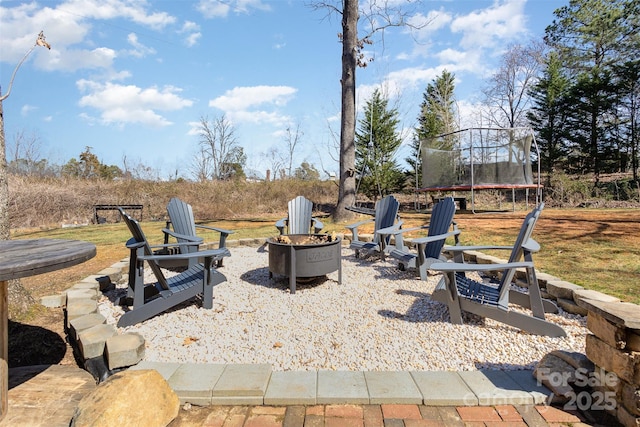 view of patio / terrace featuring a trampoline and an outdoor fire pit