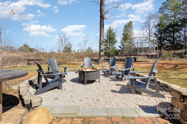 view of patio / terrace featuring an outdoor fire pit and a trampoline