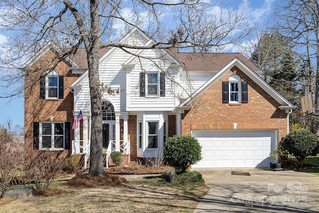 traditional-style house with a garage, driveway, and brick siding