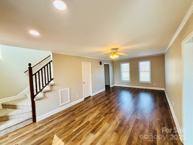 spare room with wood finished floors, visible vents, baseboards, and stairs