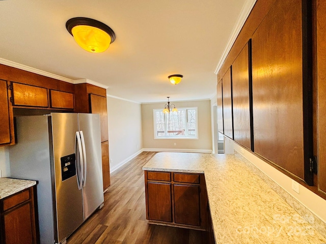 kitchen featuring stainless steel fridge, brown cabinetry, dark wood-type flooring, light countertops, and crown molding