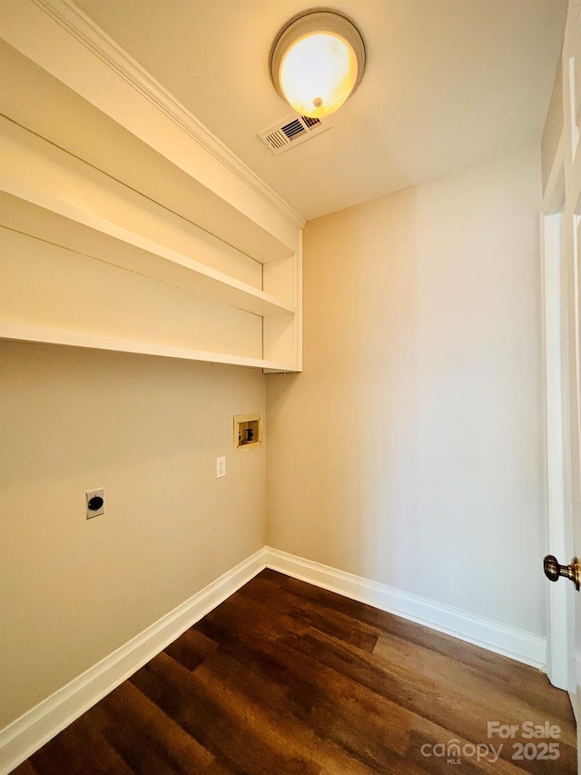 clothes washing area with hookup for a washing machine, laundry area, wood finished floors, visible vents, and baseboards