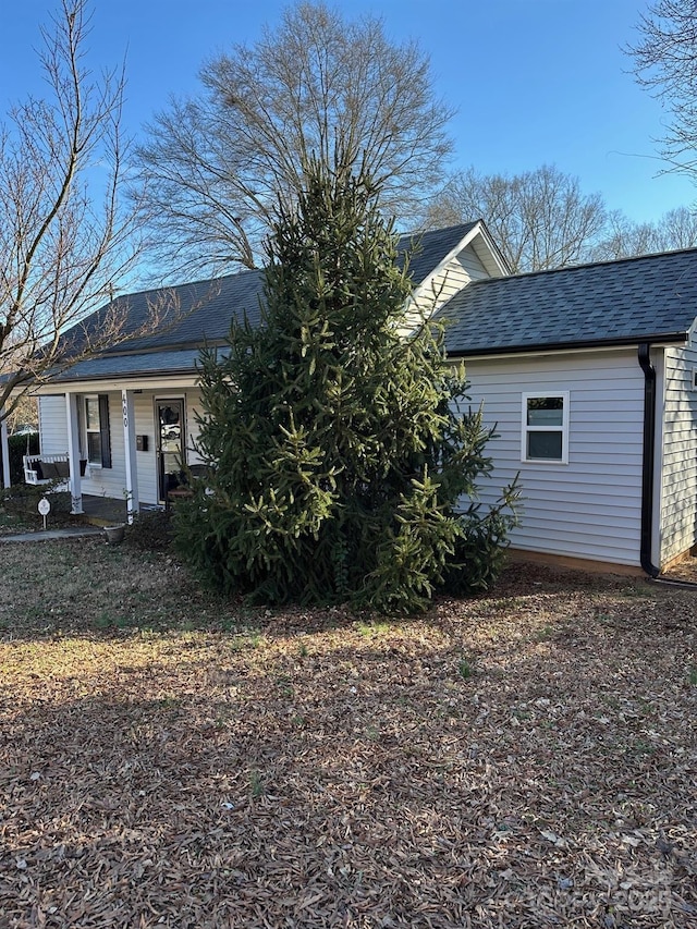 back of property featuring covered porch and roof with shingles