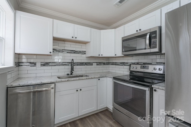 kitchen featuring stainless steel appliances, dark wood-style flooring, a sink, white cabinets, and decorative backsplash